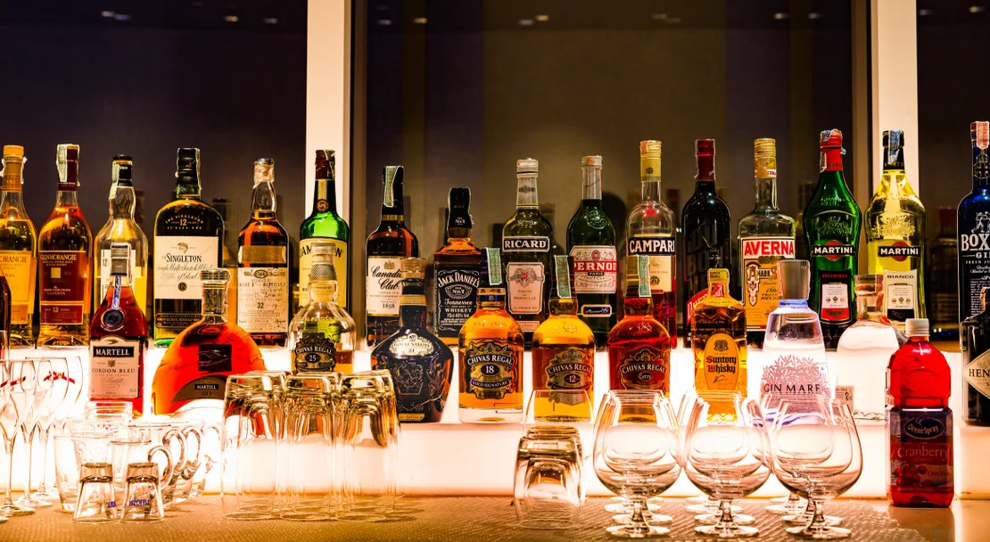 rs=w_1110,cg_true,m Bar shelf with assorted liquor bottles displayed.