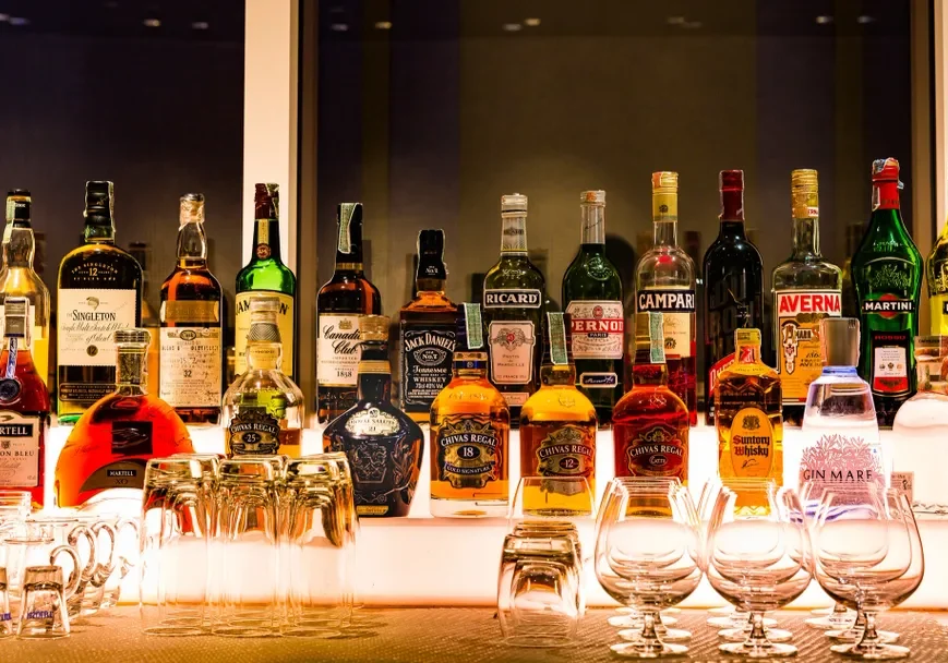 Bar shelf with assorted liquor bottles displayed.